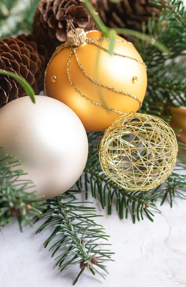 Gold and white ornaments on fir branches